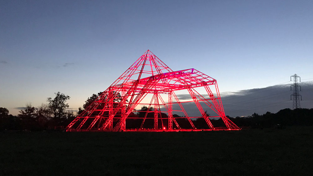 Pyramid Stage at Glastonbury, lit red by Fineline Lighting